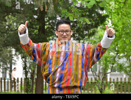 (190515) - Peking, 15. Mai 2019 (Xinhua) - sangay Tenzin zeigt traditionelle Kostüme von seiner Mutter, die auf dem Campus der Beijing Sprache und Kultur an der Universität in Peking, der Hauptstadt von China, 14. Mai 2019. Sangay Tenzin, einem BHUTANISCHEN Student von Peking, Sprache und Kultur der Universität, ist einer der Fotografen, deren Arbeiten durch eine Ausstellung angenommen wurde unter dem Motto "Vielfalt der asiatischen Zivilisationen in der Jugend die Augen", am Rande der Konferenz über den Dialog der asiatischen Zivilisationen (CDAC). In seinem Foto, ein Landwirt Radieschen fließt in einen Korb mit traditionelle Bhutanischen Häuser weit streuenden werden Stockfoto