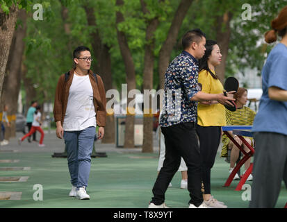 (190515) - BEIJING, Mai 15,2019 (Xinhua) - sangay Tenzin Spaziergänge auf dem Campus der Beijing Sprache und Kultur an der Universität in Peking, der Hauptstadt von China, 14. Mai 2019. Sangay Tenzin, einem BHUTANISCHEN Student von Peking, Sprache und Kultur der Universität, ist einer der Fotografen, deren Arbeiten durch eine Ausstellung angenommen wurde unter dem Motto "Vielfalt der asiatischen Zivilisationen in der Jugend die Augen", am Rande der Konferenz über den Dialog der asiatischen Zivilisationen (CDAC). In seinem Foto, ein Landwirt gießt Radieschen in einen Korb mit traditioneller bhutanischer Häuser weit hinter der Streuung. Seine Arbeit konzentriert sich auf die Landwirtschaft der Stockfoto