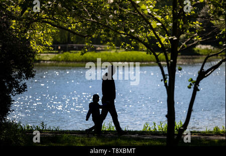 Hannover, Deutschland. 15 Mai, 2019. Ein Mann und ein Kind Spaziergang im Schatten durch den Maschpark in Hannover. Credit: Peter Steffen/dpa/Alamy leben Nachrichten Stockfoto