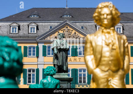 Bonn, Deutschland. 15 Mai, 2019. Lächelnd Beethoven Statuen, ein Werk des Konzeptkünstlers und Bildhauers Ottmar Hörl, stand vor dem etwas düsteren Beethoven Denkmal auf dem Münsterplatz. Ab dem 17. Mai bis 2. Juni 2019, die Kunst der Installation 'Ludwig van Beethoven - Ode an die Freude", bestehend aus 700 Beethoven Statuen über einen Meter hoch, ist auf Ansicht vor dem Beethoven Denkmal auf dem Münsterplatz. Credit: Rolf Vennenbernd/dpa/Alamy leben Nachrichten Stockfoto