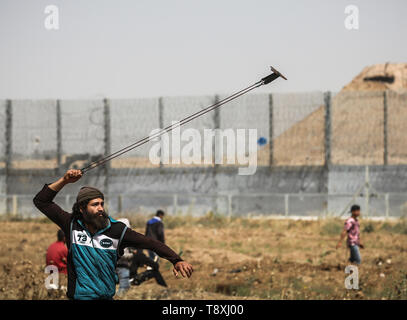 Mai 15, 2019 - Gaza, Gaza, Palästina, palästinensische Demonstranten mit einer Steinschleuder bei den Auseinandersetzungen gesehen. Palästinenser stießen mit israelischen Kräfte auf den Grenzzaun in einem Protest Kennzeichnung von 1948 die Nakba, oder 'Katastrophe'', die Hunderte von Tausenden von Palästinensern durch den Krieg begleiten die Geburt des jüdischen Staates verdrängt. (Bild: © nidal Alwaheidi/SOPA Bilder über ZUMA Draht) Stockfoto