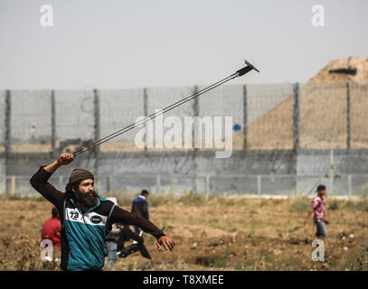 Palästinensischen Demonstrant mit einer Steinschleuder bei den Auseinandersetzungen gesehen. Palästinenser stießen mit israelischen Kräfte auf den Grenzzaun in einem Protest Kennzeichnung von 1948 die Nakba, oder der "Katastrophe", die Hunderttausende von Palästinensern durch den Krieg begleiten die Geburt des jüdischen Staates verdrängt. Stockfoto