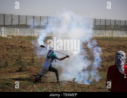 Palästinensischen Demonstrant mit einer Steinschleuder bei den Auseinandersetzungen gesehen. Palästinenser stießen mit israelischen Kräfte auf den Grenzzaun in einem Protest Kennzeichnung von 1948 die Nakba, oder der "Katastrophe", die Hunderttausende von Palästinensern durch den Krieg begleiten die Geburt des jüdischen Staates verdrängt. Stockfoto