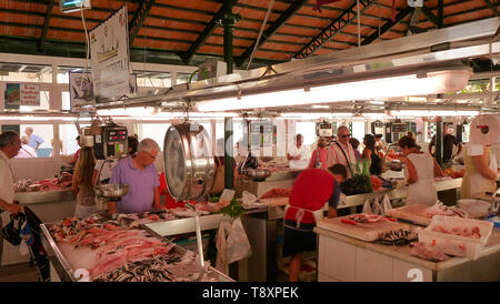 Blick auf den Fischmarkt in Ciutadella de Menorca, mit verschiedenen bunten Fisch, der für den Verkauf in den Vordergrund und touristische Kunden Stockfoto