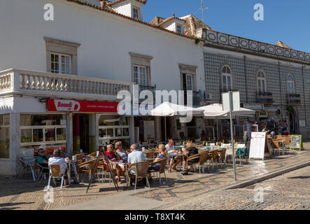 Menschen im Sonnenschein draußen Straßencafes in Praça da Republica, Tavira, Algarve, Portugal, Südeuropa sitzen Stockfoto