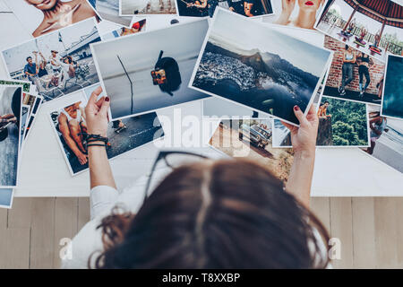 Blick von oben auf eine Frau Fotograf arbeiten im Studio. Fotografin Kontrolle Bild druckt. Stockfoto