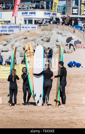 Surfer für die Fotografie auf den Fistral Beach in Newquay in Cornwall posieren. Stockfoto