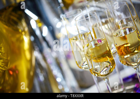 Nahaufnahme von glänzende Gläser Champagner über Schwarz, Weiß, goldenen und silbernen Ballons Hintergrund Stockfoto