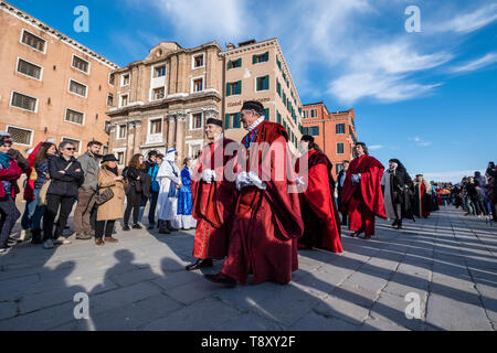 Eine Gruppe von kostümierten Menschen nimmt an der Prozession Festa delle Marie Parade entlang des Canal Grande, Canal Grande Stockfoto