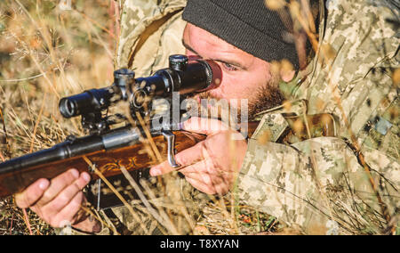 Die Streitkräfte. Camouflage. Bärtiger Mann Jäger. Jagd Fähigkeiten und Waffen Ausrüstung. Wie schalten Sie die Jagd in Hobby. Uniform Mode. Mann Jäger mit Gewehr Pistole. Militärische Operation in der Wüste. Stockfoto