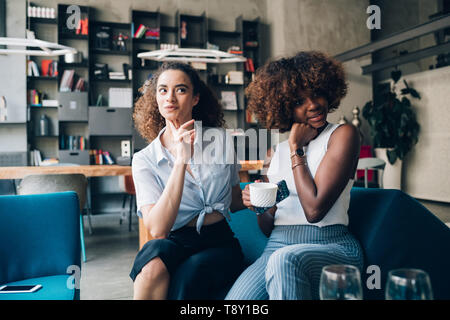 Junge Frauen zusammen Posieren und Kaffee trinken im modernen Bistro - Zusammengehörigkeit, Interaktion, fröhlichen Stockfoto