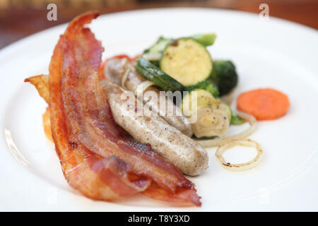 Gebratener Speck und Würstchen mit Gemüse Stockfoto