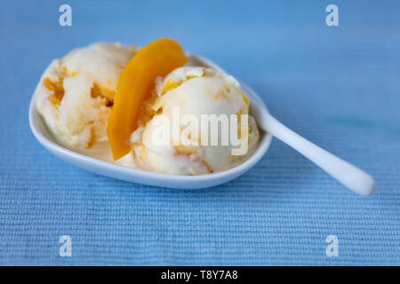 Hausgemachte mango Eis mit Joghurt Eis in eine Schüssel geben. Stockfoto