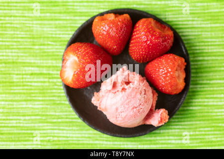 Frische hausgemachte Kugel Erdbeereis mit Erdbeeren von oben Stockfoto