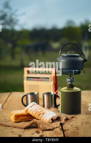 Die Zubereitung von Kaffee oder Tee auf tragbaren Gas Herd auf die Natur. Reise, Abenteuer, Campingausrüstung, im Freien. Stockfoto