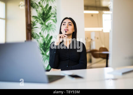 Schöne Geschäftsfrau träumen während der Arbeit am Computer in ihrem Büro Stockfoto