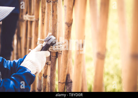 Close up Hammer in der Hand Seil zur Festsetzung der Zaun bauen. Retro und Vintage Style Natur Umwelt Idee design Hintergrund Stockfoto