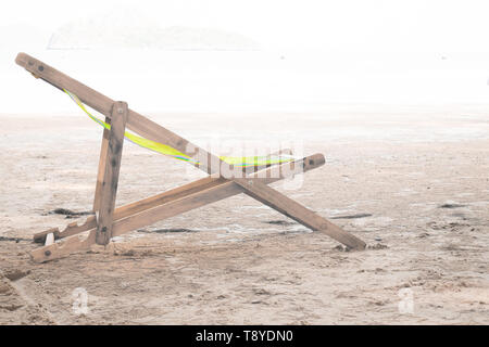 Holz- Chaiselongue auf einem weichen, weißen Hintergrund am Strand Stockfoto