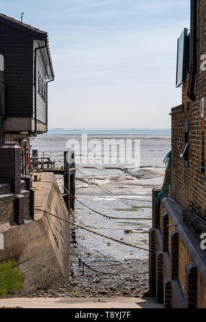 Ein schmales Boot slipway zwischen alten Gebäuden an der Alten Leigh, Leigh-on-Sea, Essex, Großbritannien. Ebbe mit vorland und alten Ketten. Thames Estuary Stockfoto