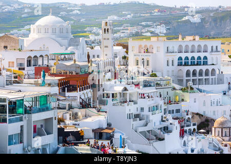 Fira, Freece - April 26, 2019: Panorama der Stadt, Dorf in der Santorini Insel mit weißen und blauen Häuser, Kirche Dome und Menschen Stockfoto