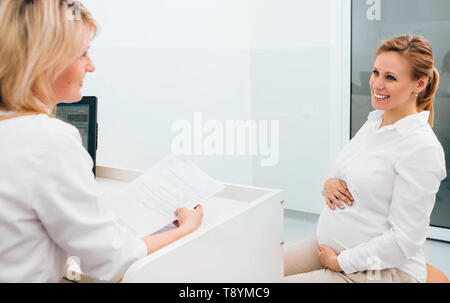 Schwangere Frau in Absprache mit Ihrem Geburtshelfer in der Klinik Untersuchungsraum Stockfoto