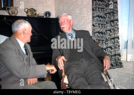 1959, historische, zwei geeignet älteren englischen Kollegen sitzen in Stühlen aus Holz in einem Zimmer vorne ein Gespräch, England, UK. Stockfoto