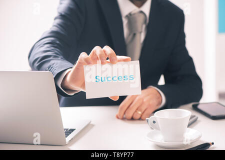 Geschäftsmann holding Business Card mit Erfolg Text auf Sie schließen nach oben Stockfoto