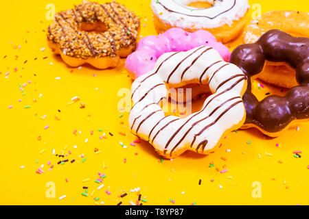 Bunte Donuts auf gelben Hintergrund. Stockfoto