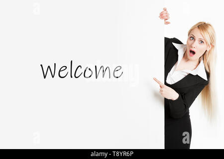 Eine blonde business Frau mit langem Haar mit einem Herzlich Willkommen Schild Stockfoto