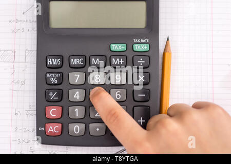 Mit dem Finger auf dem Rechner Taste Während der Mathematischen Lektion. Schule Konzept. Stockfoto