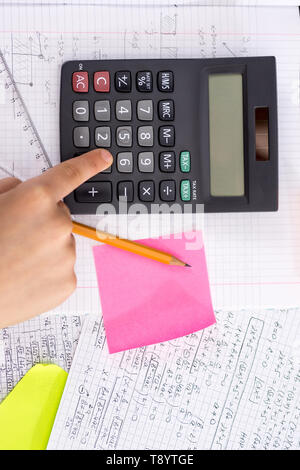 Mit dem Finger auf dem Rechner Taste Während der Mathematischen Lektion. Schule Konzept. Stockfoto