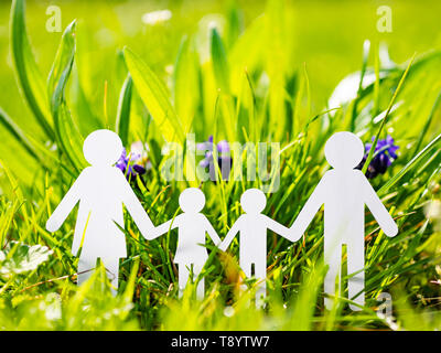 Papier Familie auf grünem Gras Hintergrund Stockfoto