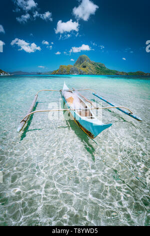 Traditionelle filippino Fisher banca Boot in der Blauen Lagune bei El Nido Bucht mit cadlao Insel im Hintergrund. Palawan, Philippinen. Stockfoto