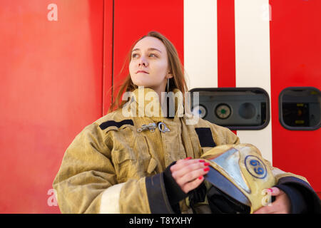 Foto von Mädchen Feuer auf der Suche auf der Seite der ständigen Bei fire truck Stockfoto