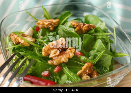 Köstlich frischer Salat mit Walnüssen in Glasschale, Nahaufnahme Stockfoto