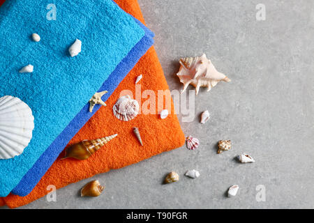 Helle Bettwäsche und Muscheln auf grau Tabelle Stockfoto