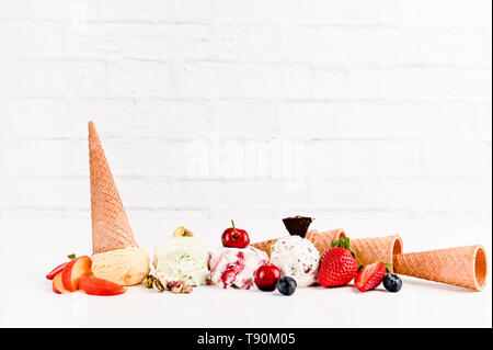 Süßes Eis in Kugeln auf einem weißen Hintergrund. Dessert mit verschiedenen Geschmacksrichtungen und frischen Beeren. Platz kopieren Stockfoto