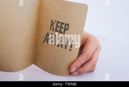 Hand mit einem Blatt Papier mit fernhalten Wortlaut Stockfoto