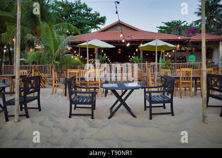 Phu Quoc, Vietnam - März 27, 2019: Tisch und Stühle vor dem Strand Restaurant mit Kellner im Hintergrund Stockfoto