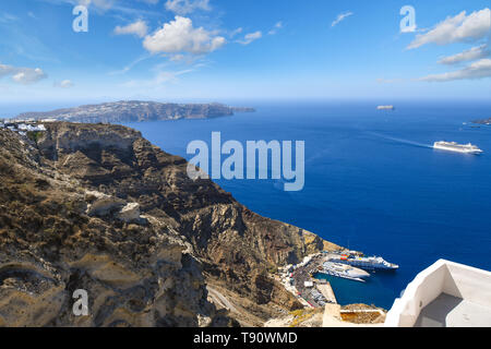 Aussicht von den Hügeln in der Nähe von Oia der Kreuzfahrt und Yacht Hafen und Schiffe auf See innerhalb der Caldera auf der Insel Santorini, Griechenland. Stockfoto