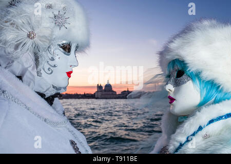 Porträts von zwei Feminine maskierten Personen in schöne kreative Kostüme, Posieren auf der Insel San Giorgio di Maggiore, feiert die venezianischen Carniva Stockfoto