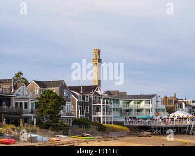 Provincetown und der Pilgrim Monument, Cape Cod, MA vom Strand aus gesehen. Ptown ist LGBT-freundlich, siehe Partei in den Vordergrund mit Gay Pride Fahnen. Stockfoto