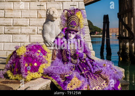 Porträt einer Feminine maskierte Person in einem schönen kreativen Kostüm, in den Gebäuden der Arsenale posiert, feiert die Venezianischen Karneval Stockfoto