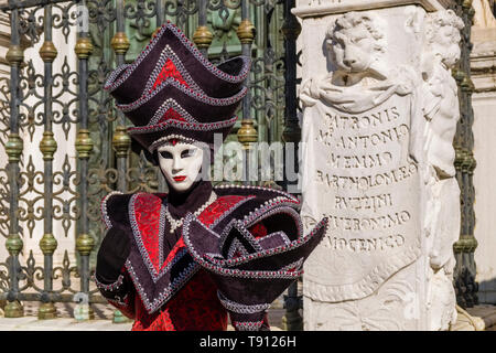 Porträt einer Feminine maskierte Person in einem schönen kreativen Kostüm, in den Gebäuden der Arsenale posiert, feiert die Venezianischen Karneval Stockfoto