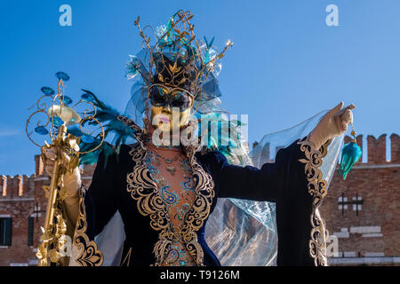 Porträt einer Feminine maskierte Person in einem schönen kreativen Kostüm, in den Gebäuden der Arsenale posiert, feiert die Venezianischen Karneval Stockfoto