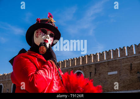 Porträt einer Feminine maskierte Person in einem schönen kreativen Kostüm, in den Gebäuden der Arsenale posiert, feiert die Venezianischen Karneval Stockfoto