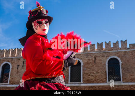 Porträt einer Feminine maskierte Person in einem schönen kreativen Kostüm, in den Gebäuden der Arsenale posiert, feiert die Venezianischen Karneval Stockfoto