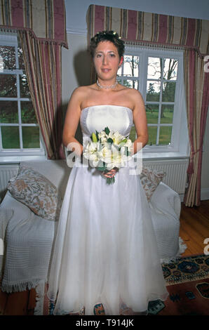 Braut In der traditionellen weißen Kleid Holding Blumenstrauß Stockfoto