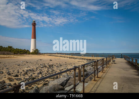 Barnegat Leuchtturm auf Long Beach Island, NJ, an einem sonnigen Frühlingstag mit blauen Himmel mit Wolken Stockfoto