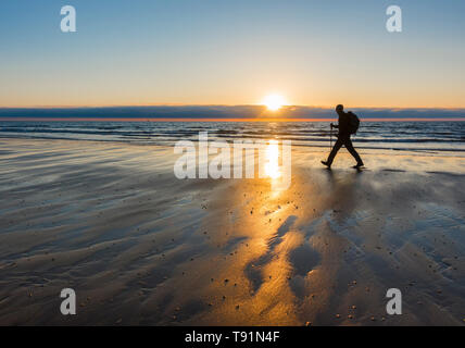 Seaton Carew, County Durham, UK. 16. Mai 2019. Wetter: ein Wanderer auf der England Coast Path bei Sonnenaufgang auf Seaton Carew Beach an der nördlichen Ostküste. Donnerstag prognostiziert einen warmen und sonnigen Tag für die meisten UK vor dem kühleren Wetter bewegt sich in für das Wochenende zu sein. Credit: Alan Dawson/Alamy leben Nachrichten Stockfoto